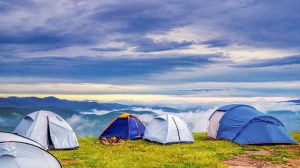 Clouds surround pitched tents on high ground
