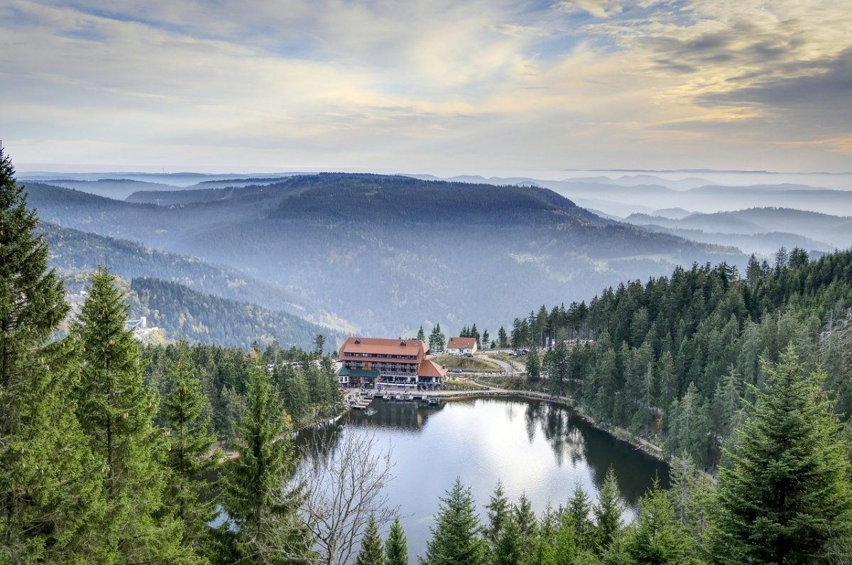 the mummelsee lake with a breathtaking view of hills and mountains behind it