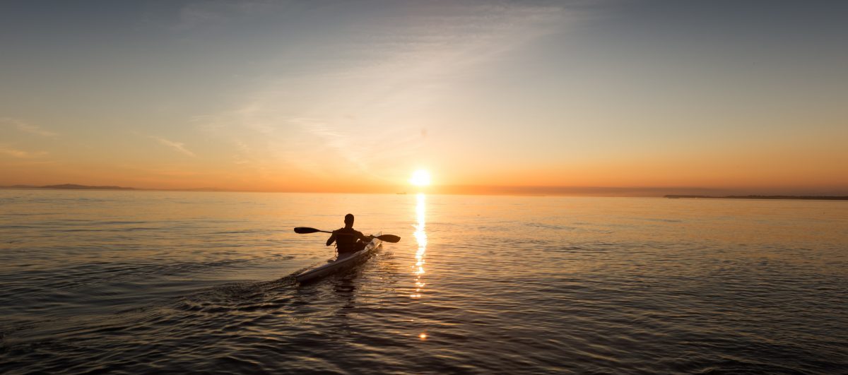 a man kayaking during sunset a man kayaking during sunset