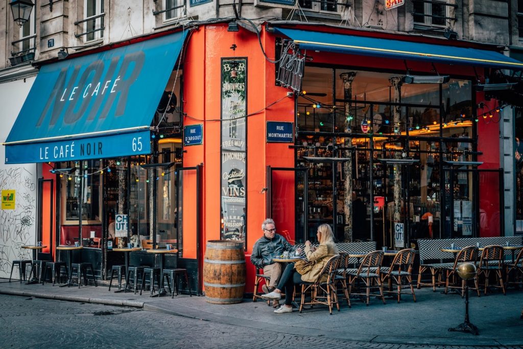 A couple sitting outside a cafe in Paris, France