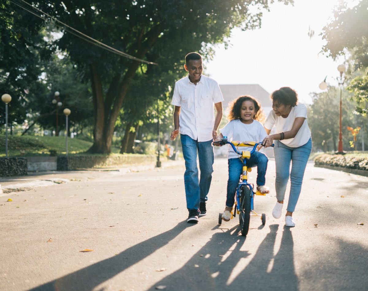 parents teaching their child how to bike