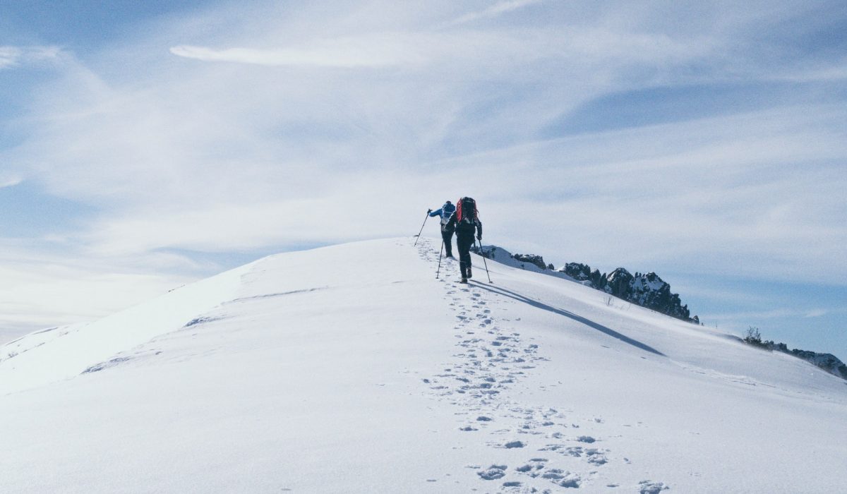 Trekking in snow two people trekking in an steep snow mountain