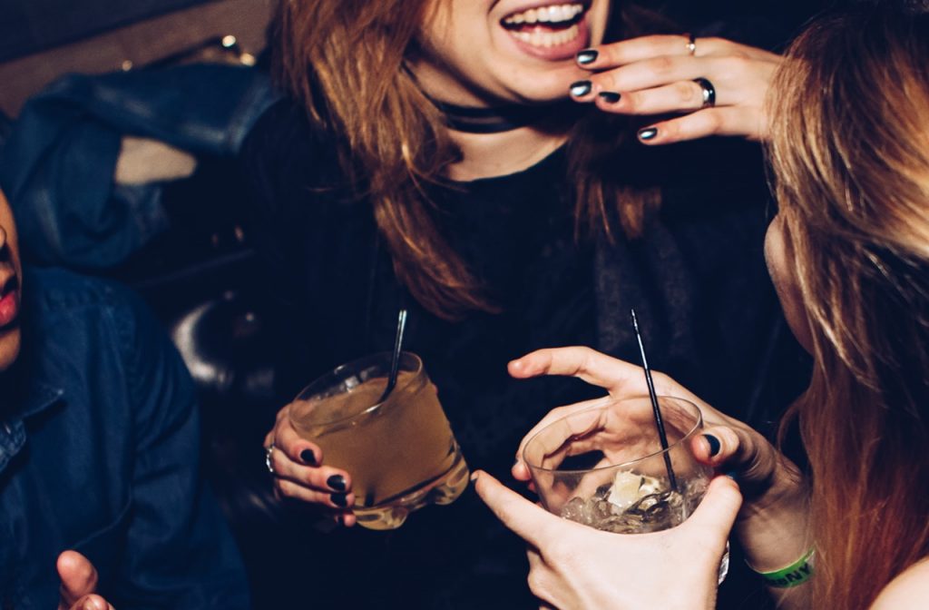 Two girls holding drinks at a party