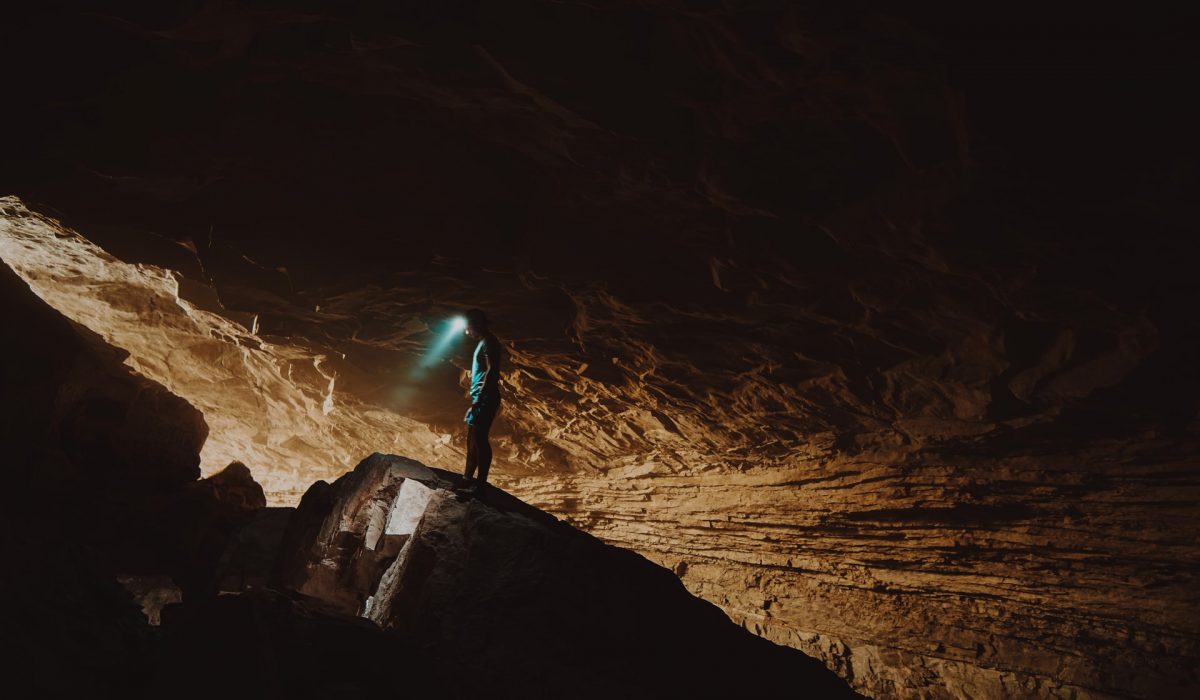 a man wearing a headlight caving