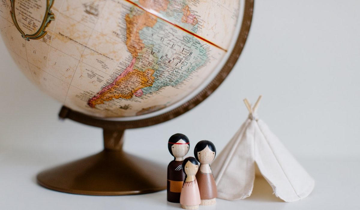 Culture Shock a family outside a tent with a globe behind them