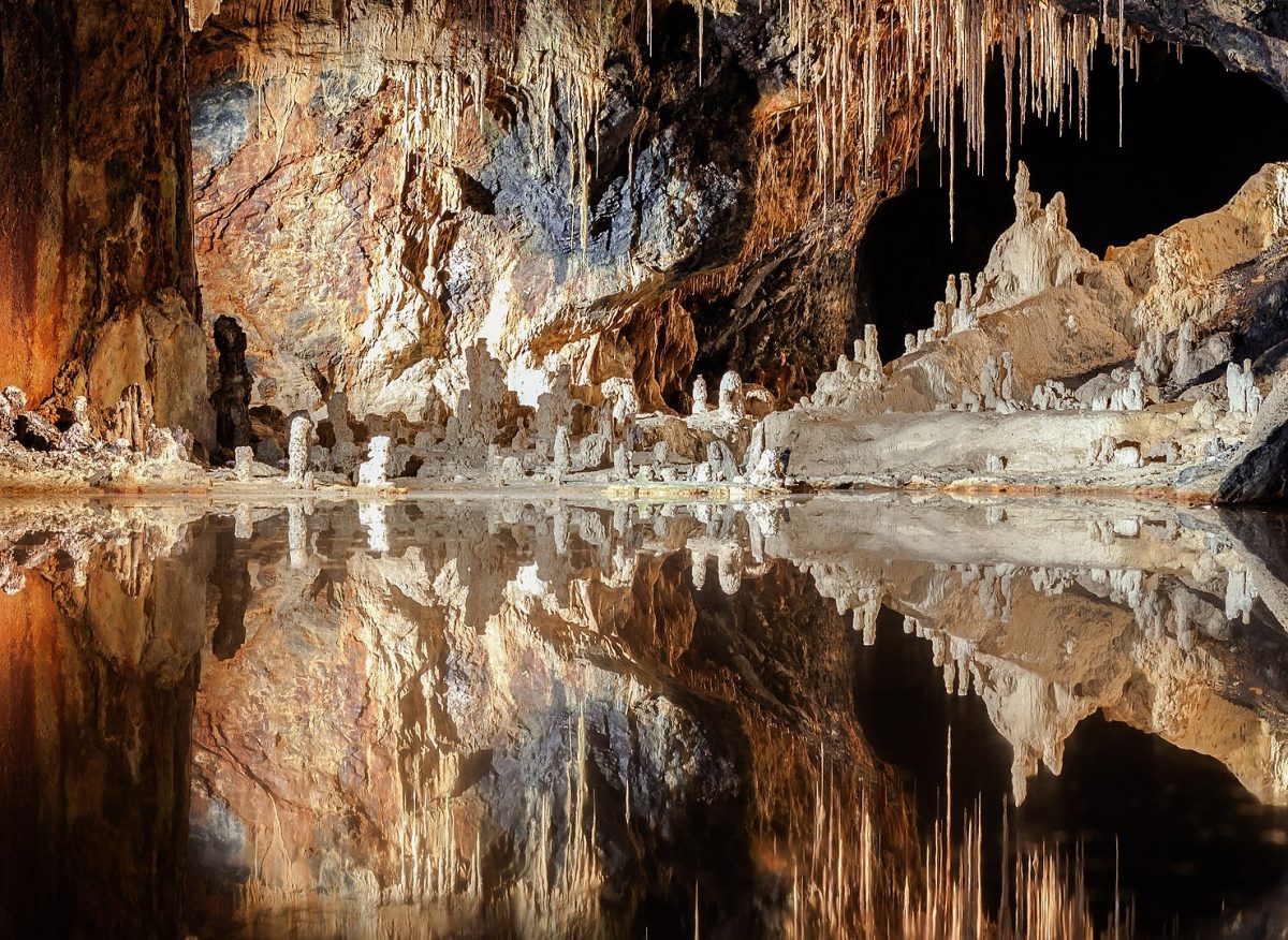 a stunning reflection of the stalagmites in a cave pool