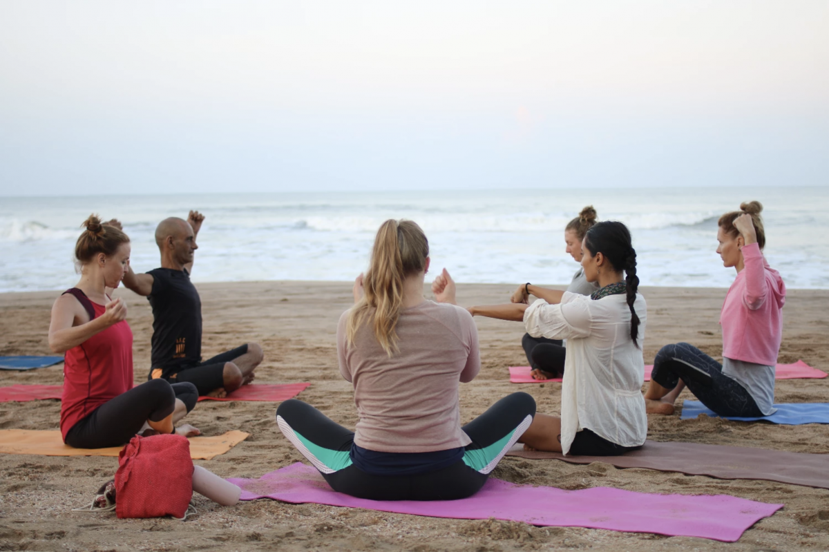a group stretching before a beachfront yoga