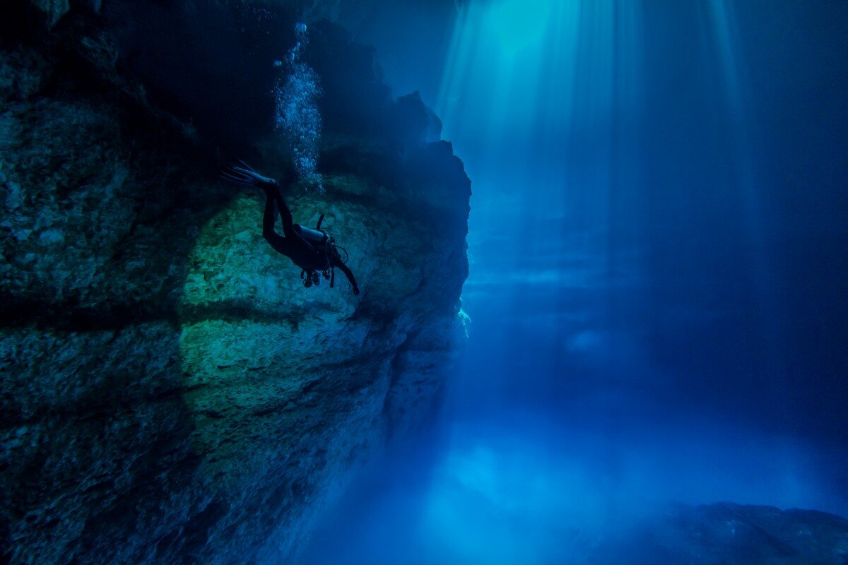 a person swimming into an underground cave