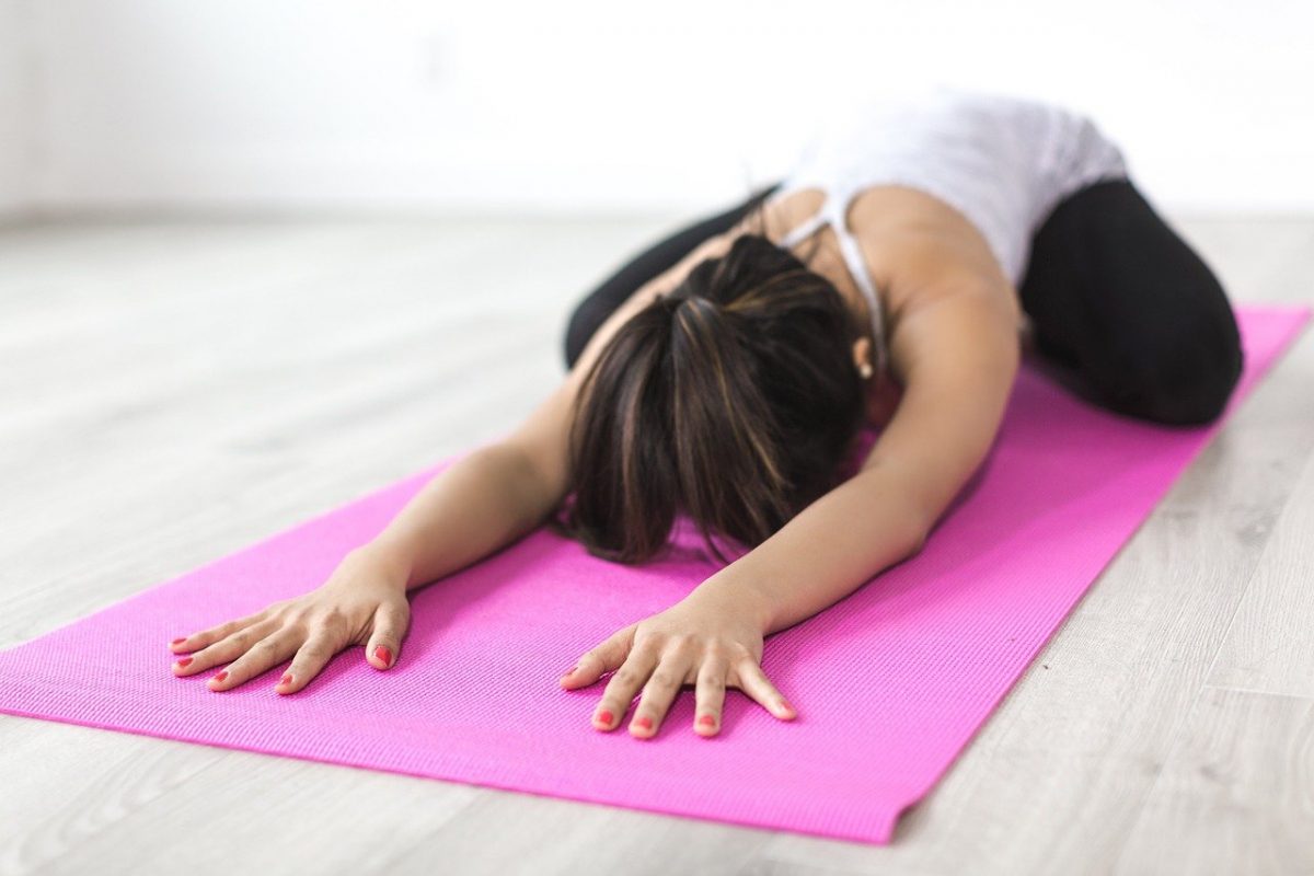 a woman doing yoga in a pink mat