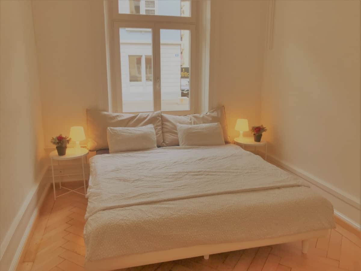 an Airbnb room with a white bed and two bedside table with lamps an Airbnb room with a white bed and two bedside table with lamps