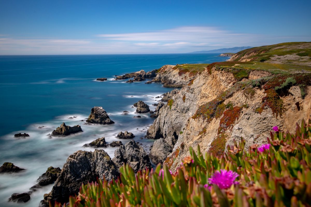 a craggy cliff in a bay filled with huge rocks