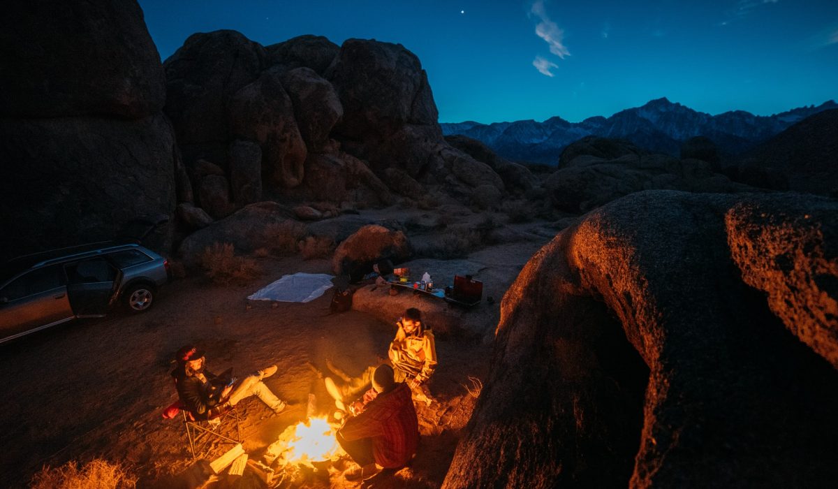 a group of people car camping between giant rocks