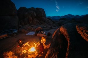 a group of people car camping between giant rocks