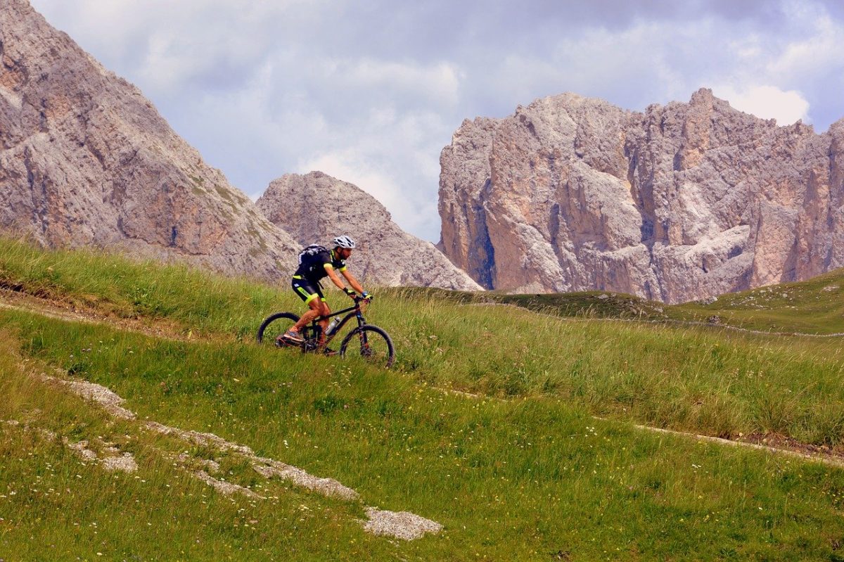 a biker in front of impressive rugged cliffs