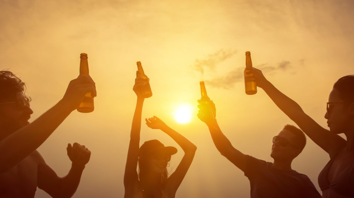 a group of friends drinking at by the beach during sunset