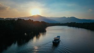 a boat cruising a river in Kampot