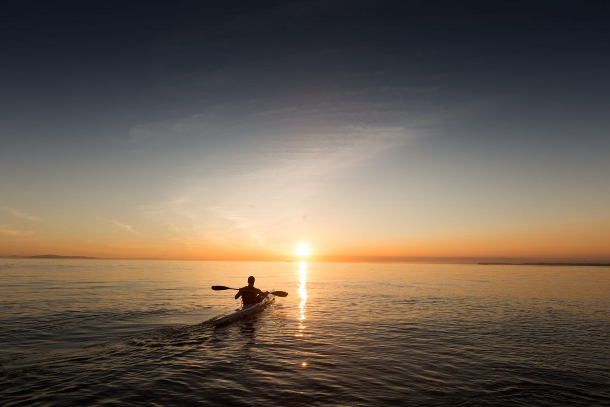 a man kayaking during sunset