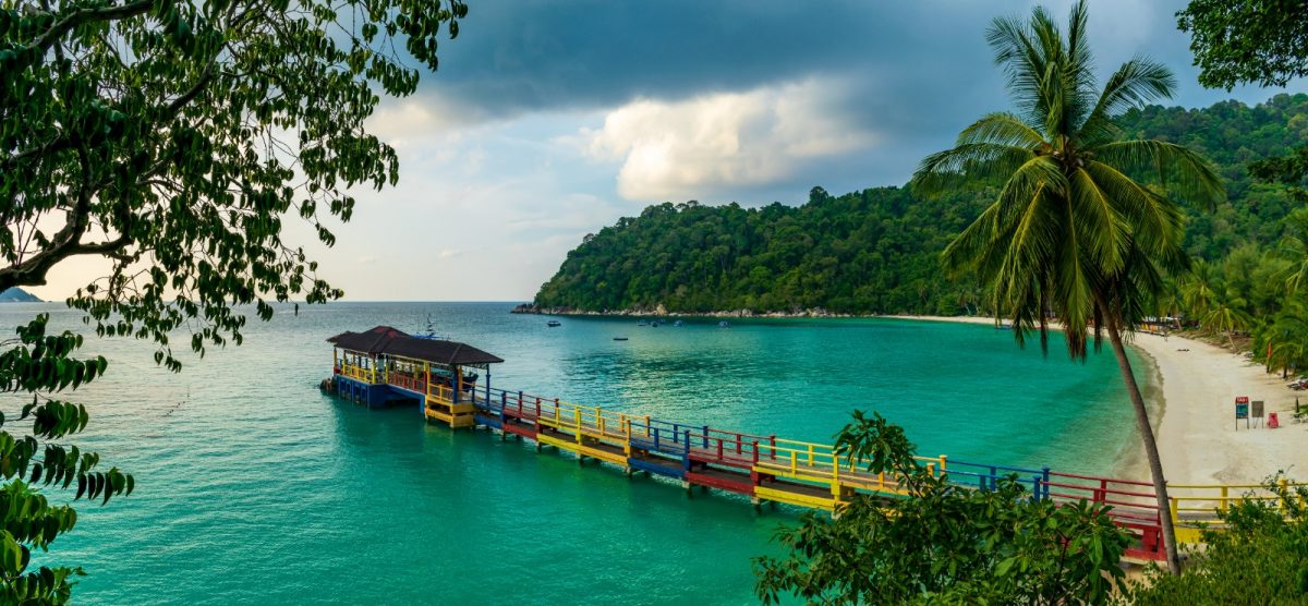 a colorful walkway on top of the turquoise waters