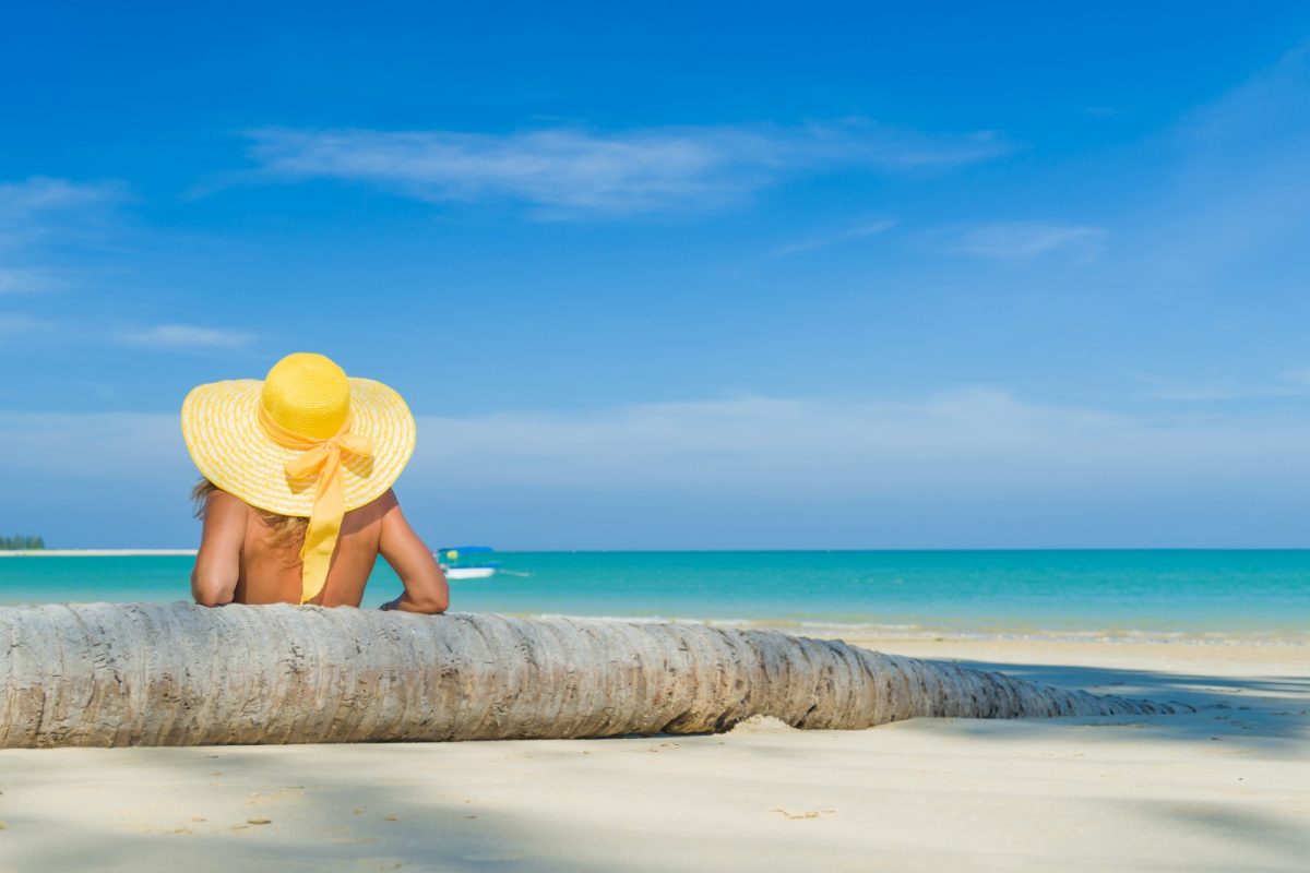 a woman with yellow hat lounging on the fine sands of perhentian islands