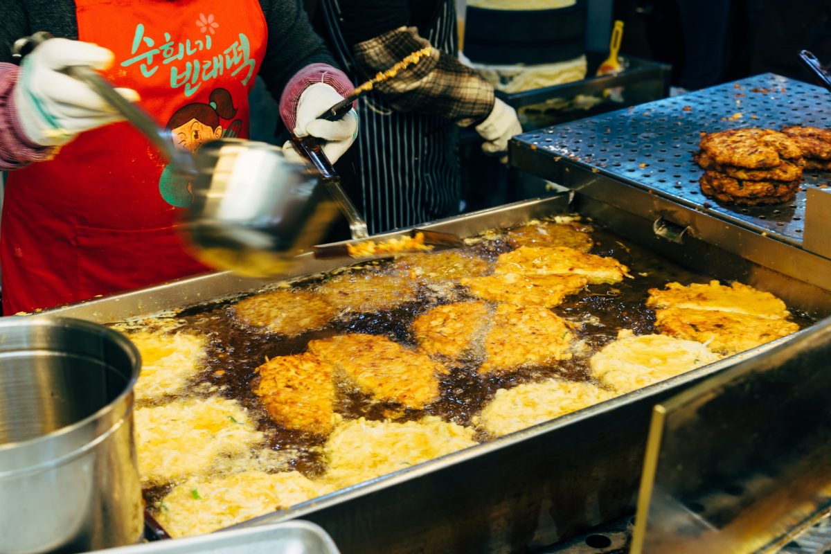 a vendor in gwangjang market frying a bindaetteok a vendor in gwangjang market frying a bindaetteok
