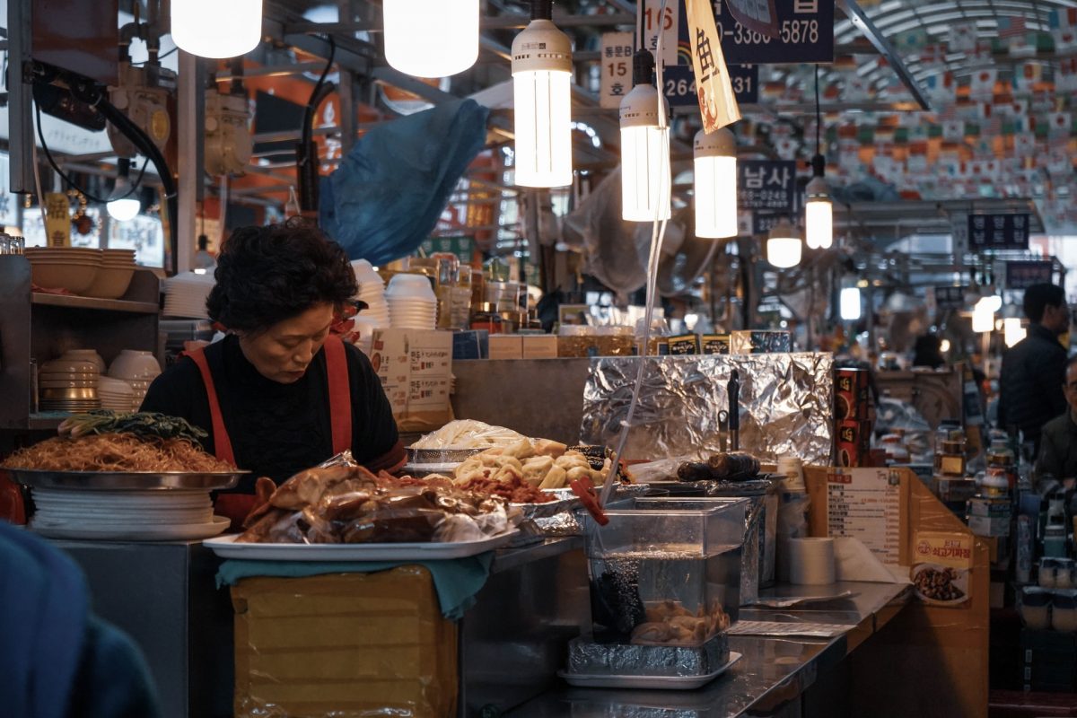 a vendor in a stall in gwangjang market a vendor in a stall in gwangjang market
