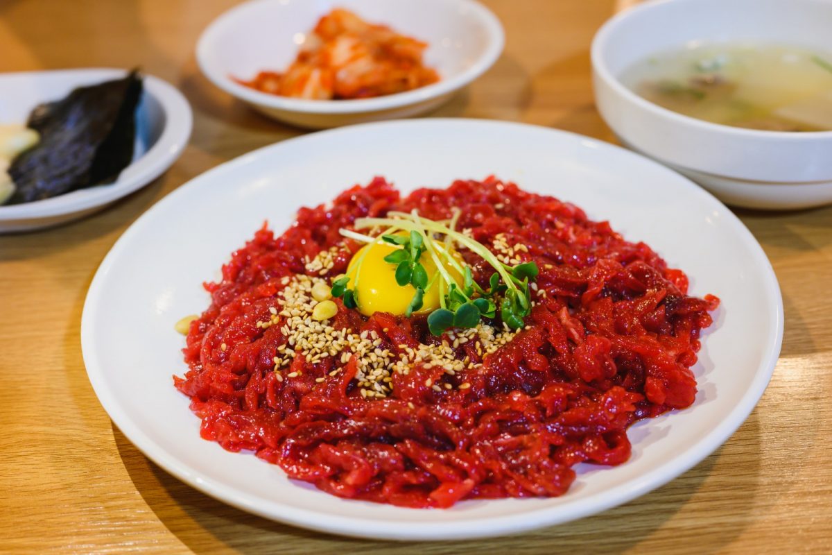 A plate of red meat with egg yolk A plate of red meat with egg yolk