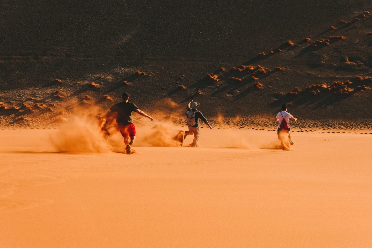 travelers running in the sand dunes 