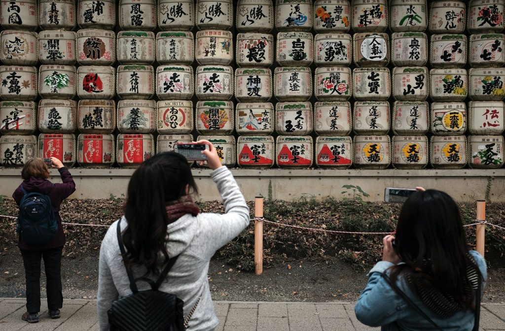 Tourists taking photos of sake barrels