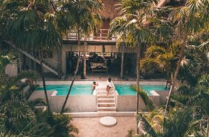 Man and woman at a poolside hotel in Tulum
