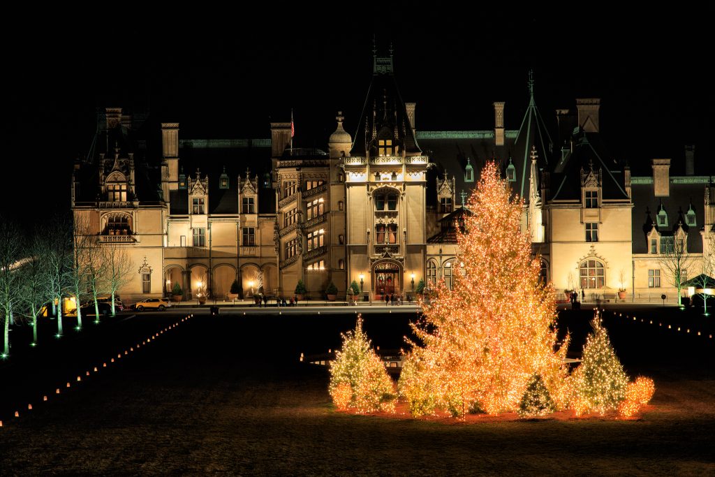 Biltmore Estate in Asheville with illuminated Christmas trees in the foreground