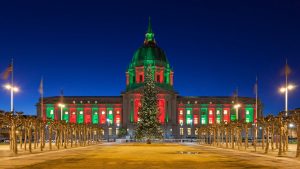 San Francisco City Hall adorned with red and green illumination during Christmas