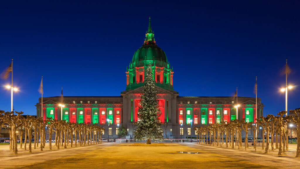 San Francisco City Hall adorned with red and green illumination during Christmas