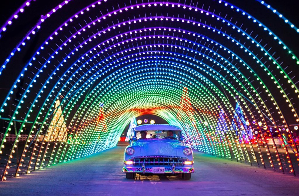 Vintage car driving through the rainbow tunnel at Christmas in Color