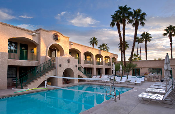 Desert Sun Resort’s pool amenities with lounge chairs and volleyball net.