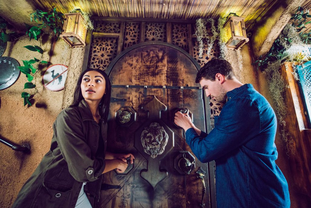 Man and woman standing in front of a grand wooden door. Man and woman standing in front of a grand wooden door.