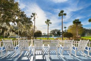 White chairs lined up overlooking the Jekyll Island Club Resort’s poolside amenities.