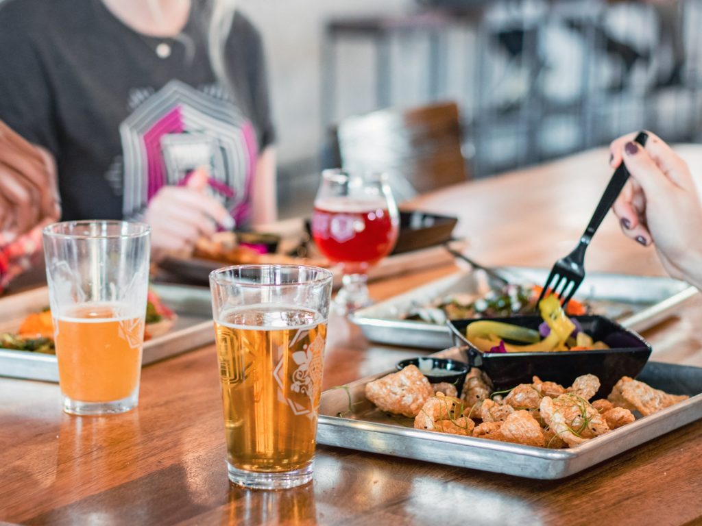 Close-up view of two glasses of beer and a glass of wine with a platter of shrimp with vegetables. Close-up view of two glasses of beer and a glass of wine with a platter of shrimp with vegetables.