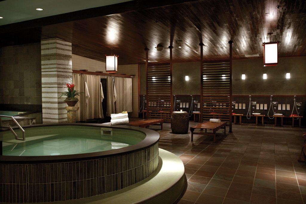 Dimly lit rooms with small pools and shower stations inside Kabuki Springs and Spa.