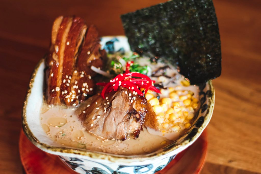 Close-up shot of a bowl of ramen topped with meat, corn, and nori sheets, at Marufuku Ramen in SF Japantown.