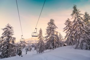 Snow covered mountain slopes with ski lifts.