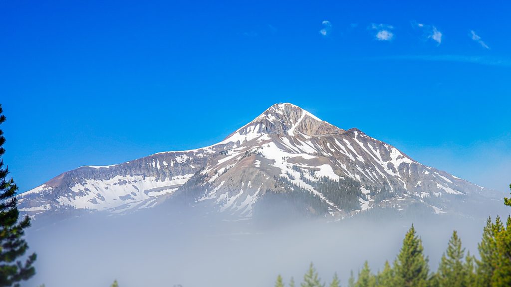Snow-capped peaks of mountains at Big Sky, Montana;  one of the best places to visit in the US in May.