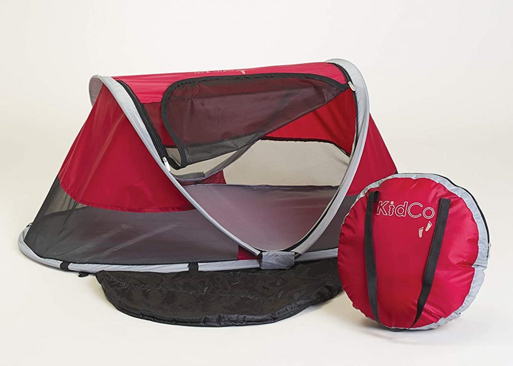 KidCo Peapod travel bassinet in red with a carry bag.