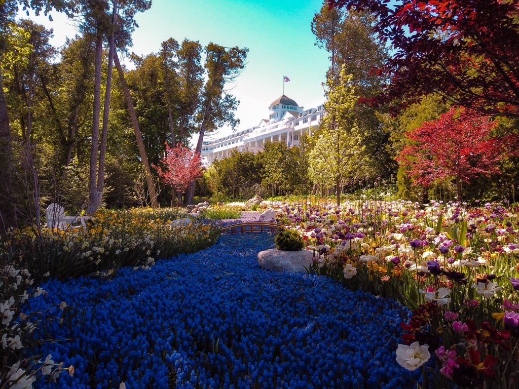 Garden with different colored flora and foliage in bloom during spring at Mackinac Island, one of the best places to visit in May in the USA