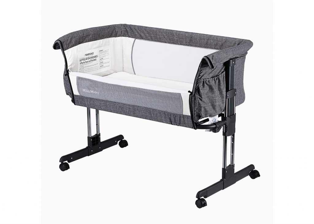 Mika Micky travel bassinet in gray with a sidewall lowered.