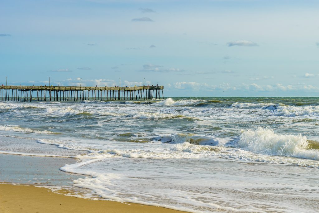Ocean waves crashing onto the sandy shores of Virginia Beach, one of the best places to visit in May in the USA