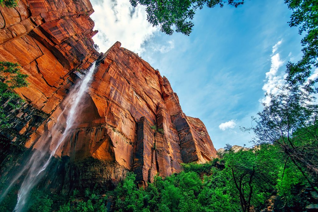 Worm's eye view of water flowing down cliffs at Yosemite National Park, California; one of the best places to visit in May in the USA.