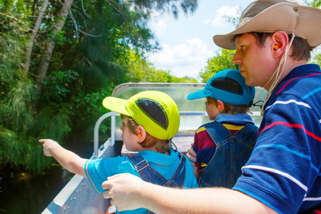 Two little kids and a man on a boat along the waterways of Everglades National Park in Florida. Two little kids and a man on a boat along the waterways of Everglades National Park in Florida.