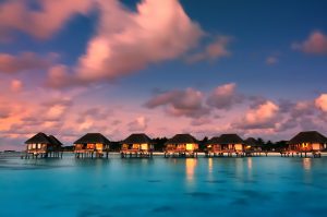 best-time-to-visit-maldives Water bungalows in Maldives against a twilight sky.