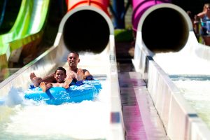 Grown man and young boy sliding down the Vortex slide at Mountain Creek Waterpark.