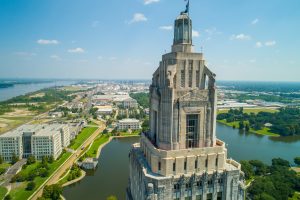 Aerial shot of the Louisiana State Capitol Building with Downtown Baton Rouge in the background.